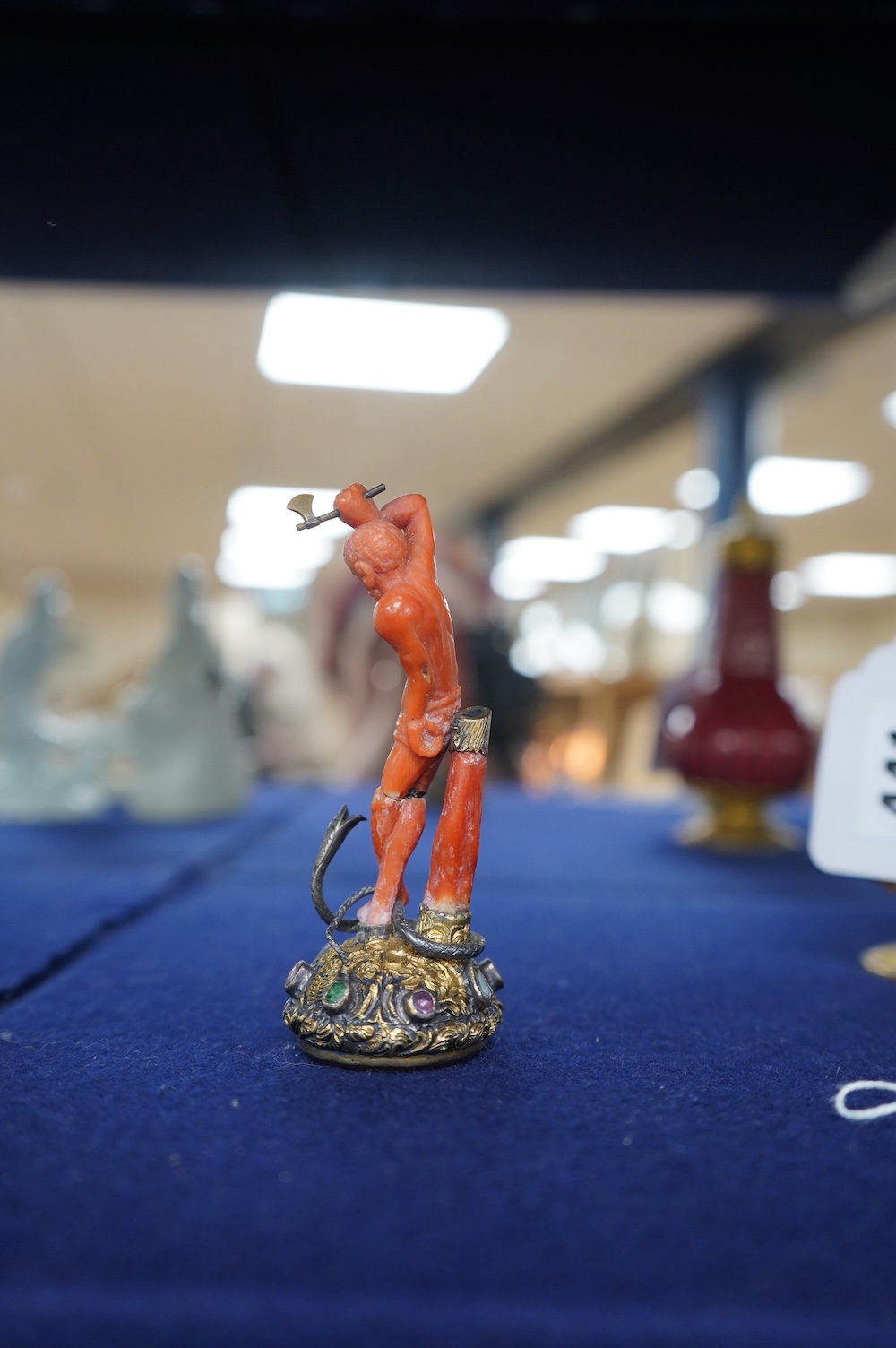 A 19th century French? gilt white metal, coral and multi gem-set table seal, modelled as a gentleman attacking a serpent with an axe, on a rustic gem set oval base, inset with carnelian, 93mm. Condition - poor